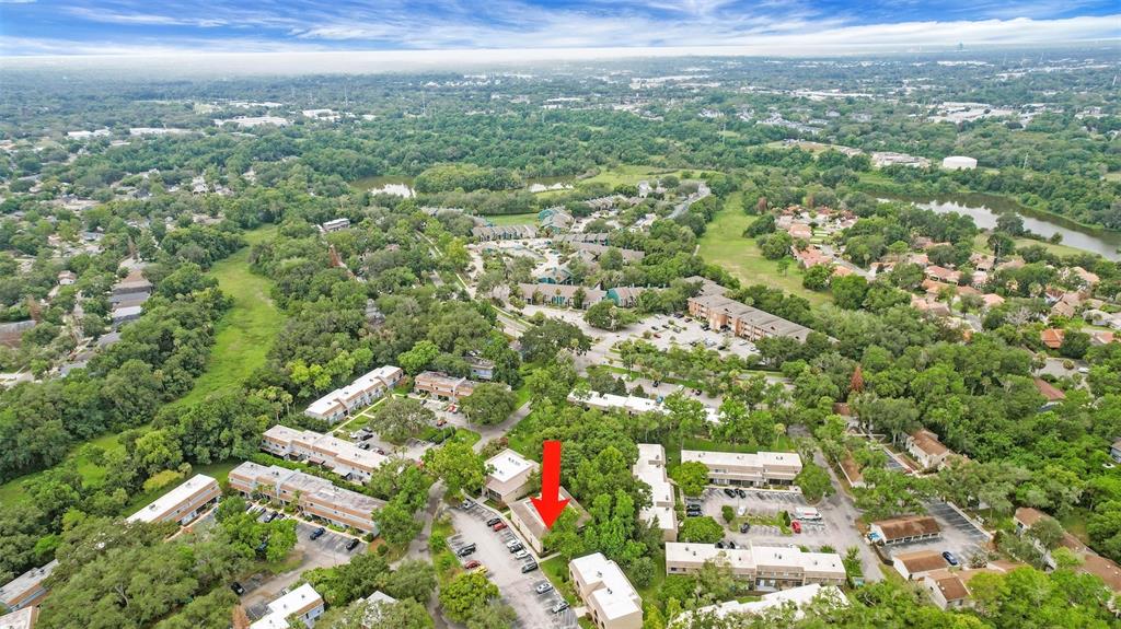 An aerial view shows a multi-story apartment complex surrounded by trees and parking lots — 220 MOREE LOOP UNIT 2, WINTER SPRINGS, FL