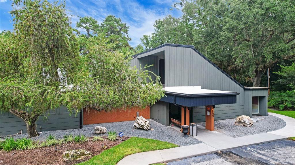 A modern house with gray vertical siding, a flat-roofed entryway, and a gravel front yard — 220 MOREE LOOP UNIT 2, WINTER SPRINGS, FL