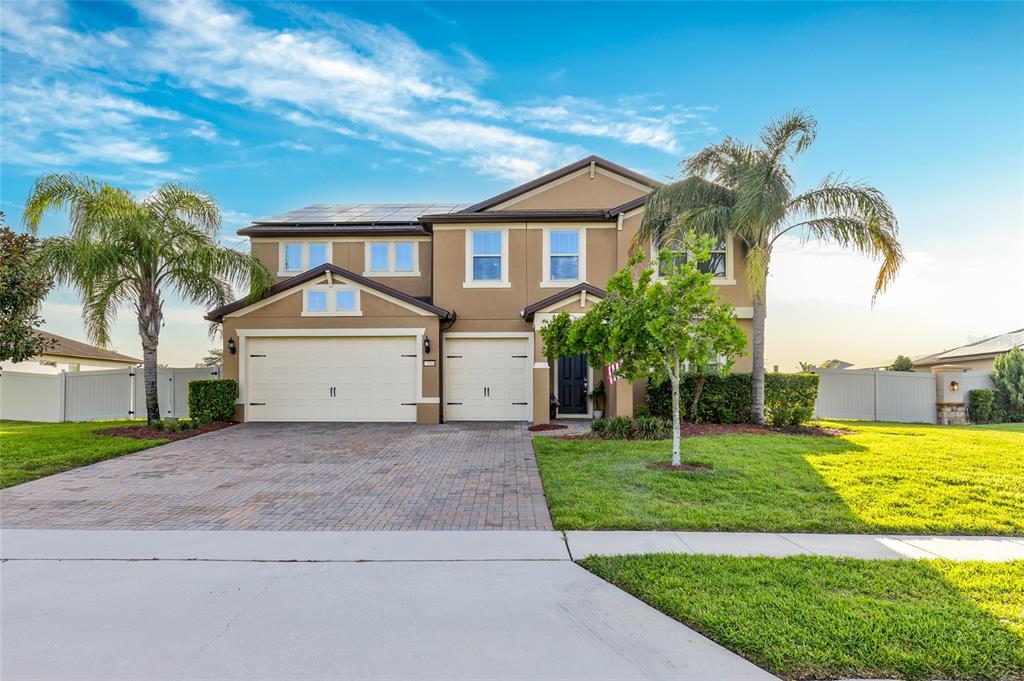 A two-story suburban house with a paved driveway, a three-car garage, and palm trees — 3344 KAYAK WAY, ORLANDO, FL