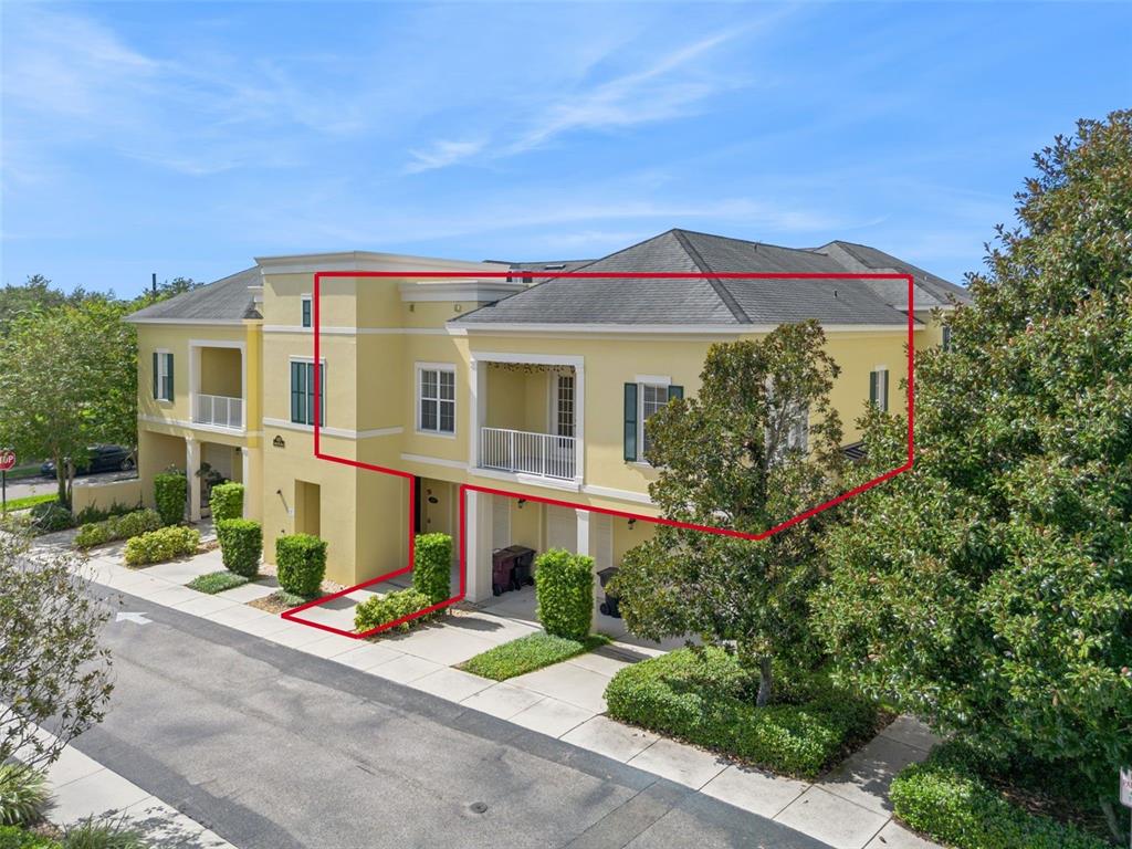An exterior view of a two-story yellow townhouse with a balcony and a red outline — 1819 COMMON WAY ROAD UNIT 203, ORLANDO, FL