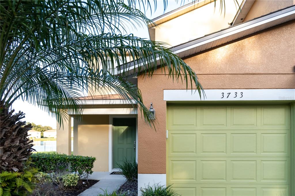 A view of a house exterior featuring a green garage door and front door — 3733 EAGLE PRESERVE POINT, SANFORD, FL
