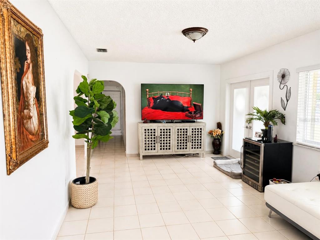 A living room features white tile floors, a large television, and a potted fiddle leaf fig — 20890 SW 236TH STREET, HOMESTEAD, FL