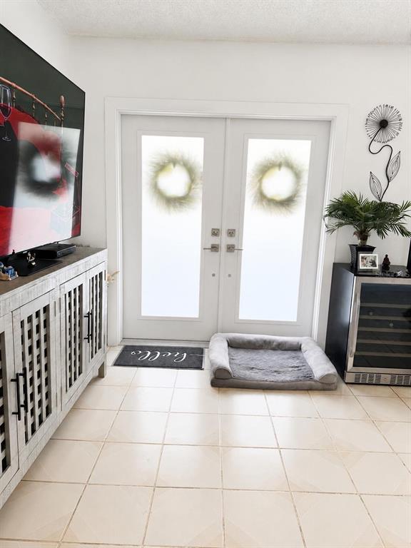A room features tiled floors, a white double door, a TV console, and a pet bed — 20890 SW 236TH STREET, HOMESTEAD, FL