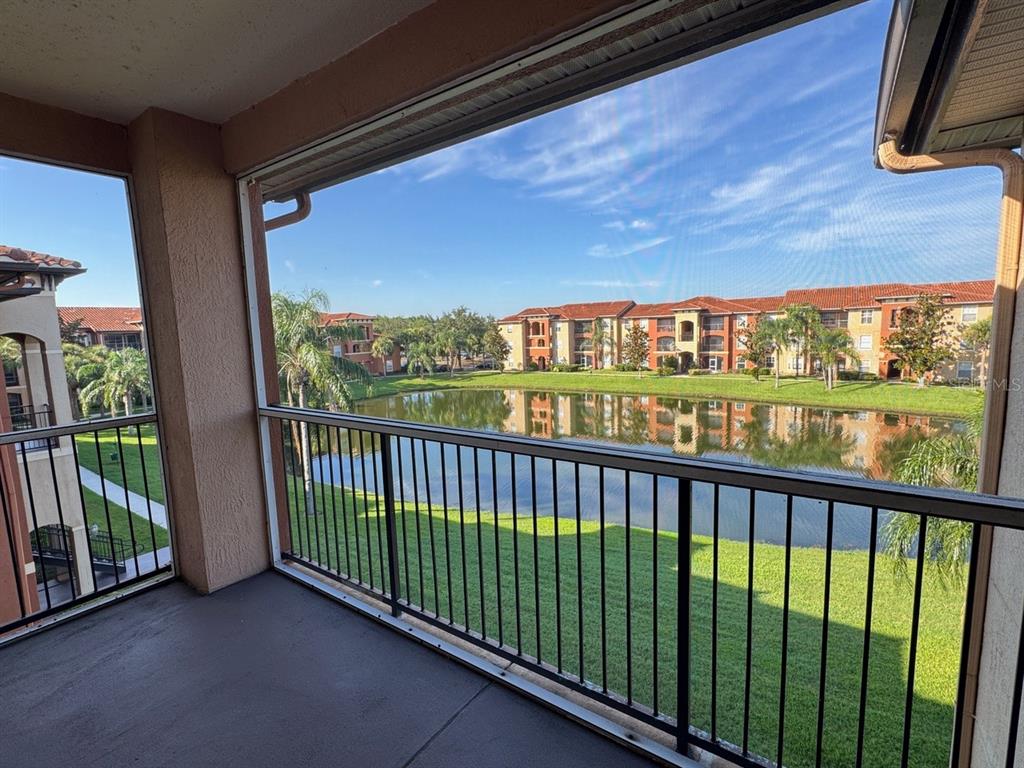 A paved walkway leads to the entrance of a Mediterranean-style clubhouse with arched windows — 5536 METROWEST BOULEVARD UNIT 8-311, ORLANDO, FL