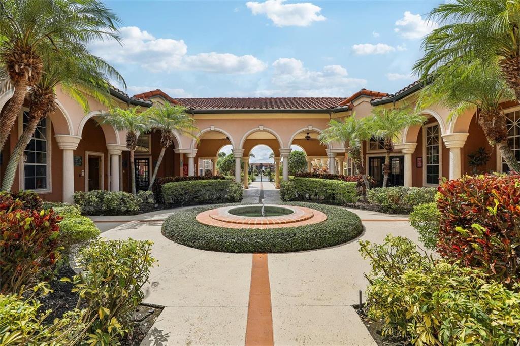 An outdoor covered bar area features stone columns, arched openings, and several metal bar stools — 5536 METROWEST BOULEVARD UNIT 8-311, ORLANDO, FL