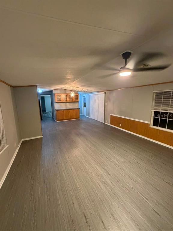An open-concept living area features gray wood-look flooring, light gray walls, and wood wainscoting — 17689 SE 14TH STREET, SILVER SPRINGS, FL