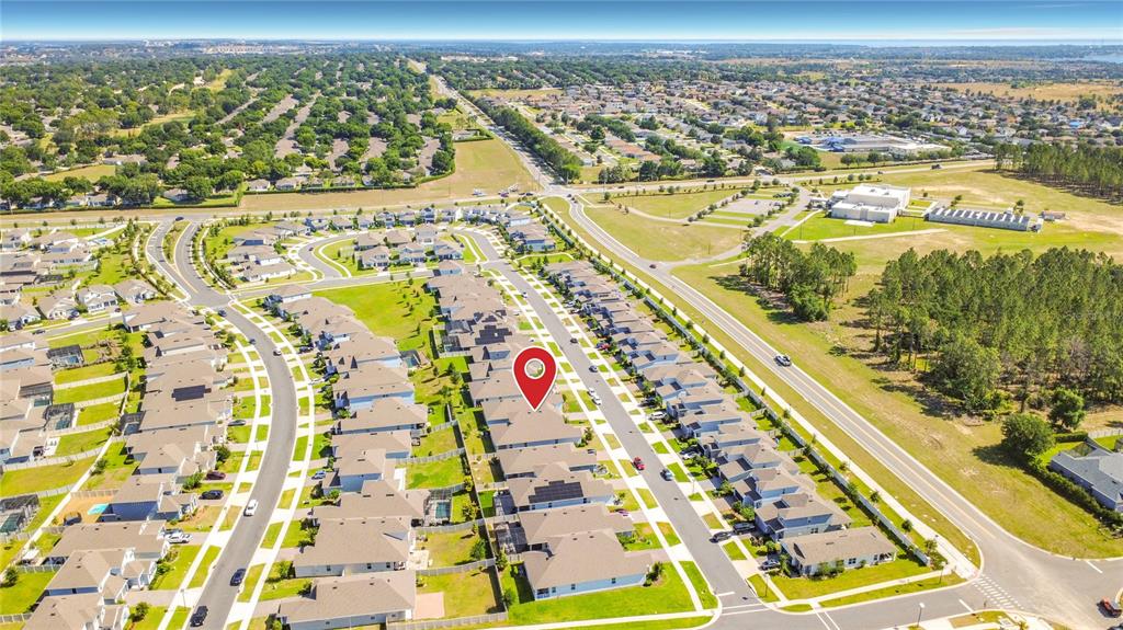 This aerial view shows a residential neighborhood with houses, streets, and a red location pin — 4485 DAVOS DRIVE, CLERMONT, FL