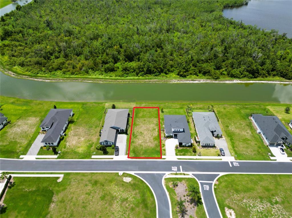 An aerial view shows a vacant residential lot outlined in red between two existing houses — 465 ADAMS VIEW LANE, AUBURNDALE, FL