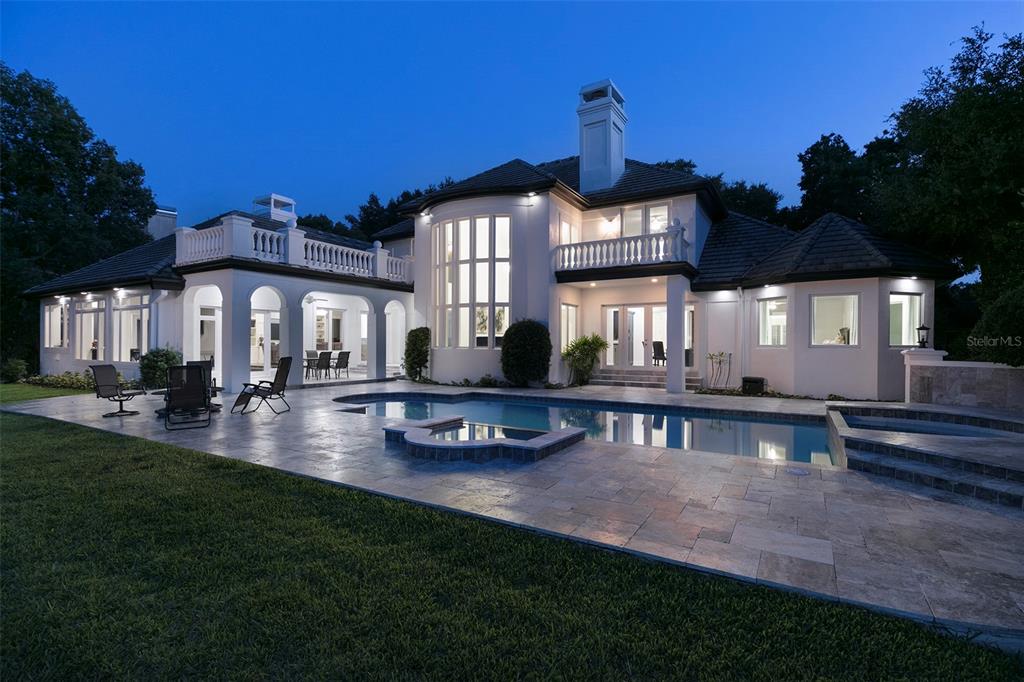 A two-story house with a swimming pool, patio, and balcony at twilight — 6462 DEACON CIR, WINDERMERE, FL