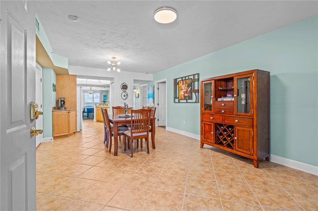 A dining area with tile flooring, a wooden hutch, and a table set for four — 2055 S ATLANTIC AVENUE UNIT 307, DAYTONA BEACH SHORES, FL