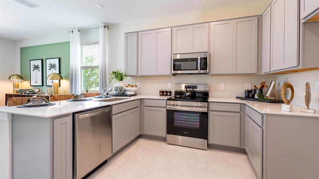 A kitchen features light gray cabinets, stainless steel appliances, and white countertops — 6081 ZEN WAY, CLERMONT, FL