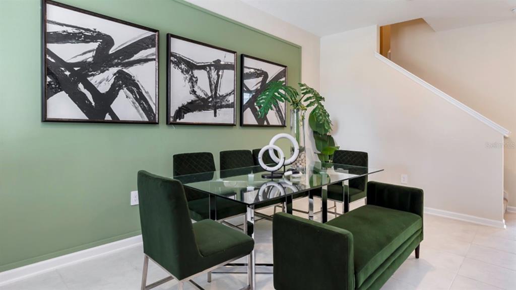 A dining room features a glass table, green velvet chairs, and three abstract wall prints — 6081 ZEN WAY, CLERMONT, FL