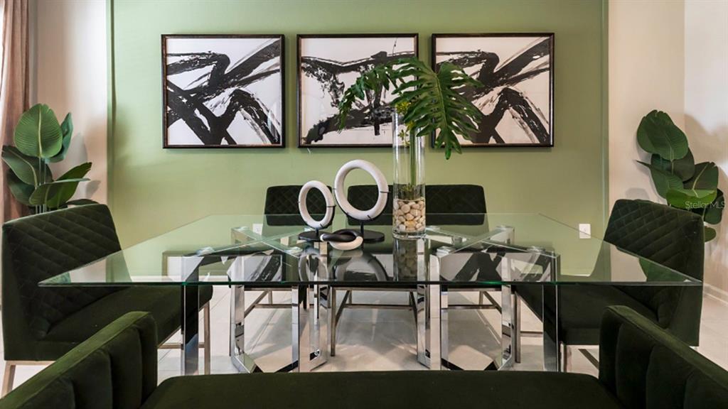 A dining room features a glass-top table, green velvet chairs, and three abstract wall art pieces — 6081 ZEN WAY, CLERMONT, FL