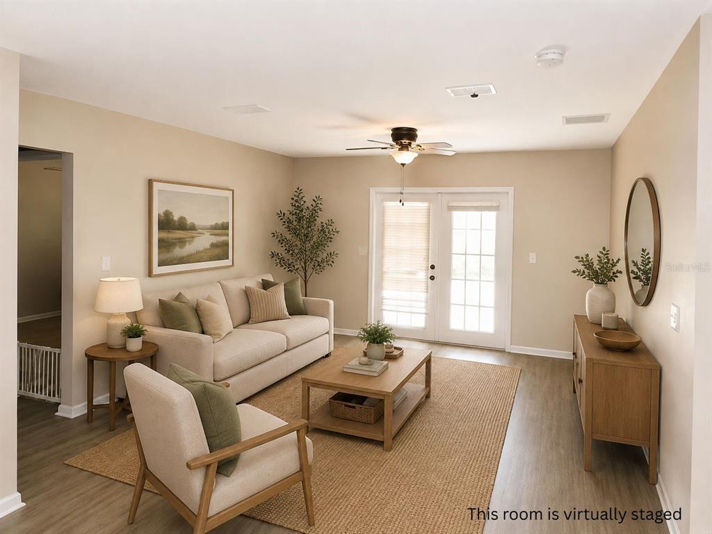An empty room with light-colored walls, wood-look flooring, a ceiling fan, and glass patio doors — 901 SW PECAN STREET, KEYSTONE HEIGHTS, FL