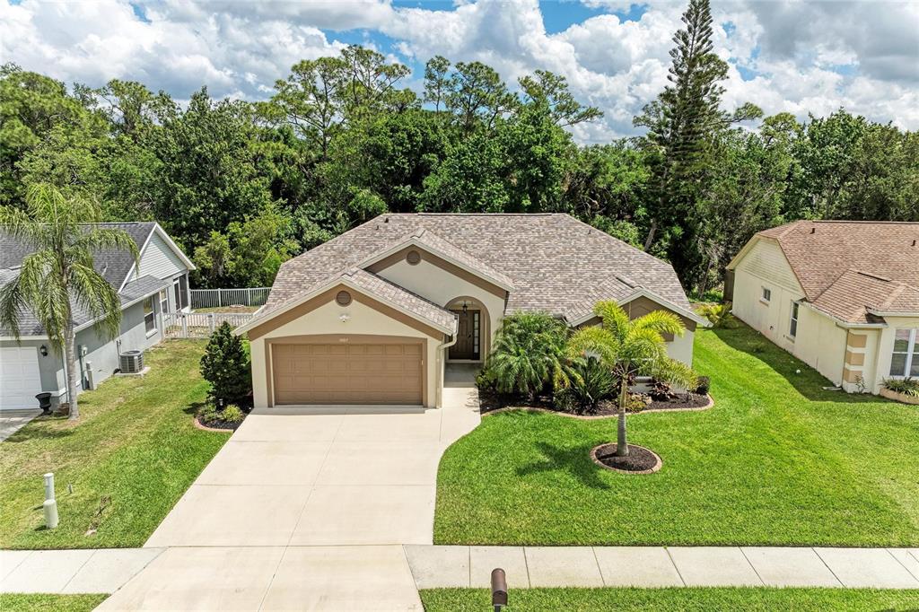 An aerial view of a single-story suburban house with a two-car garage and lawn — 1007 50TH STREET E, BRADENTON, FL
