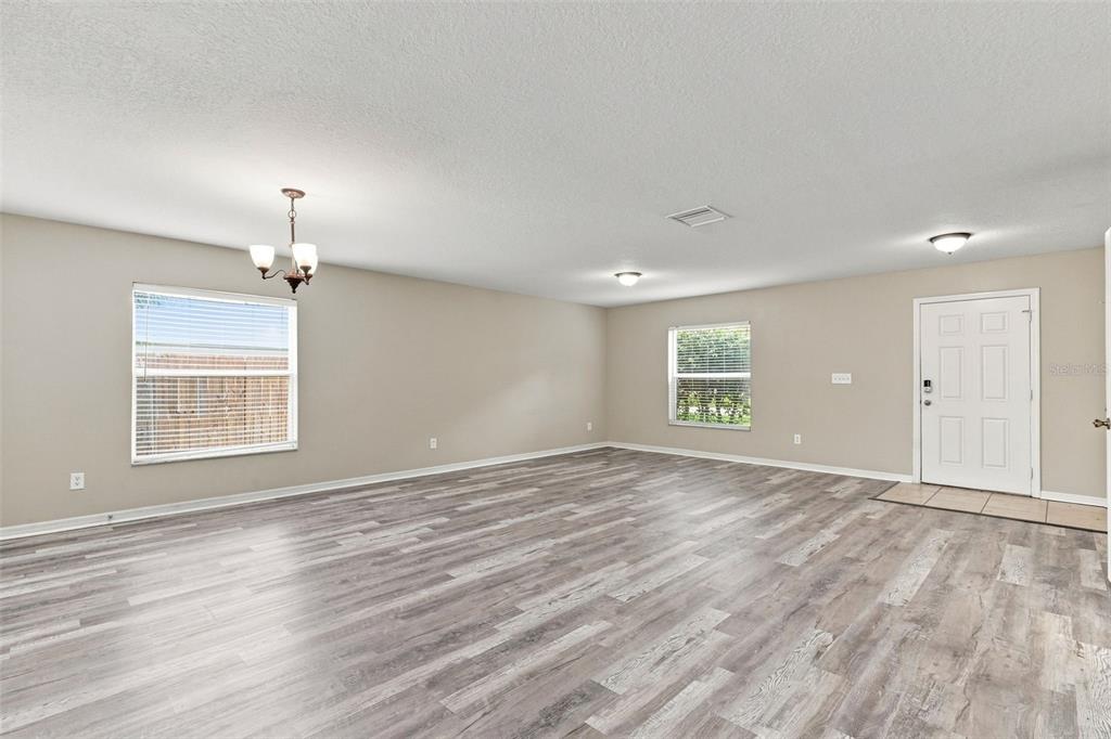 A home office features a dark wood desk with a marble top, chairs, and wood flooring — 5123 CELLO WOOD LANE, WESLEY CHAPEL, FL