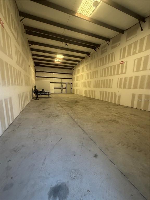 An empty warehouse space features unfinished drywall walls, a concrete floor, and exposed ceiling beams — 5475 DOVE DRIVE UNIT 14 & 15, NEW PORT RICHEY, FL