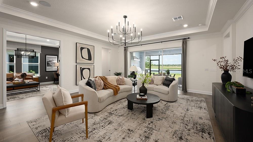 A modern kitchen features a large white island, dark cabinetry, and stainless steel appliances — 5412 GUNWALE DRIVE, COCOA, FL
