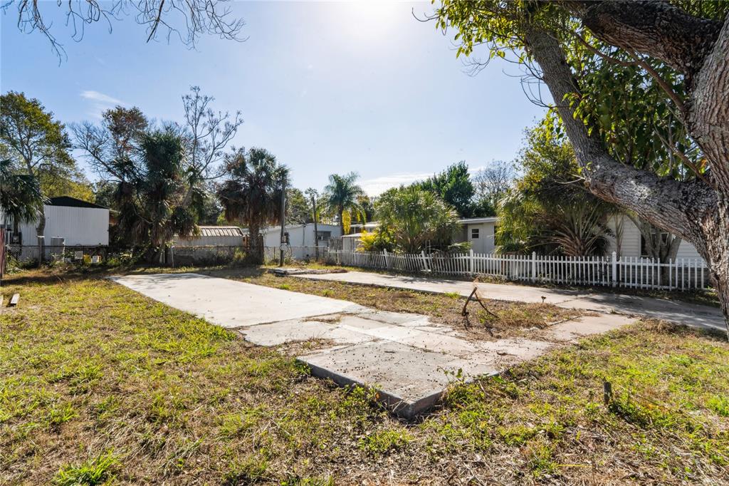 An aerial view shows a vacant lot with two concrete pads between two mobile homes — 736 DRIFTWOOD LANE, TARPON SPRINGS, FL