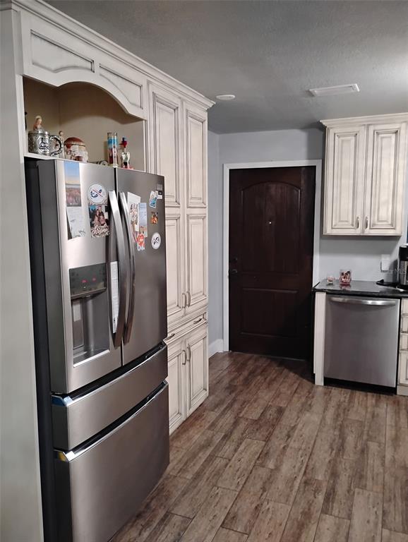 A kitchen features stainless steel appliances, off-white cabinetry, and wood-look flooring — 2101 N ATLANTIC AVENUE UNIT 18, DAYTONA BEACH, FL