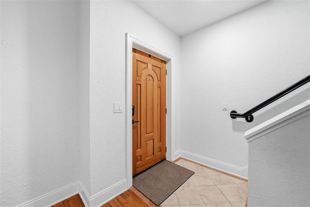 An entryway features a wooden front door, tiled floor, and a staircase with a handrail — 2236 SOHO BAY COURT, TAMPA, FL