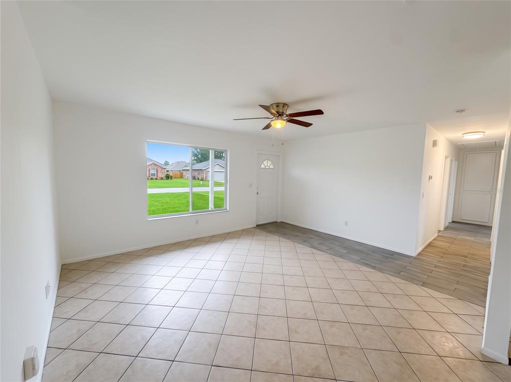 A kitchen with wood cabinets, tile flooring, and a dining table near a large window — 731 SW 24TH STREET, VERO BEACH, FL