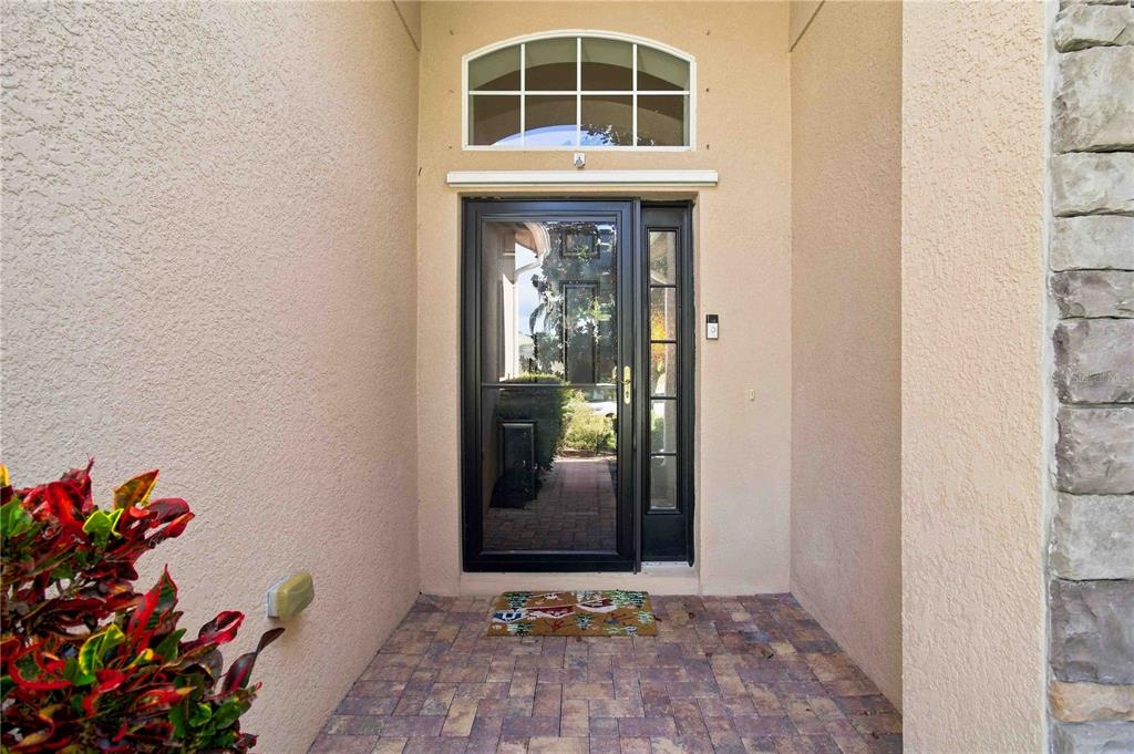 A front entryway features a glass storm door, a transom window, and stone wall accents — 6733 45TH TERRACE E, BRADENTON, FL