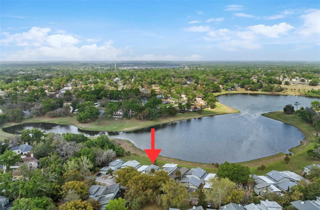 An aerial view shows a lake surrounded by residential houses and lush green trees — 1318 CHEBON CT COURT Unit E-F, APOPKA, FL