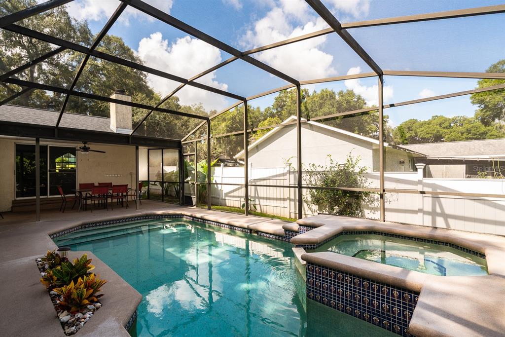 A screened-in patio features a swimming pool, a raised spa, and a dining set — 116 QUAIL RIDGE COURT, SANFORD, FL