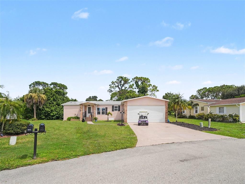 A light pink single-story house features a two-car garage and a front lawn — 19808 FRENCHMANS COURT, NORTH FORT MYERS, FL