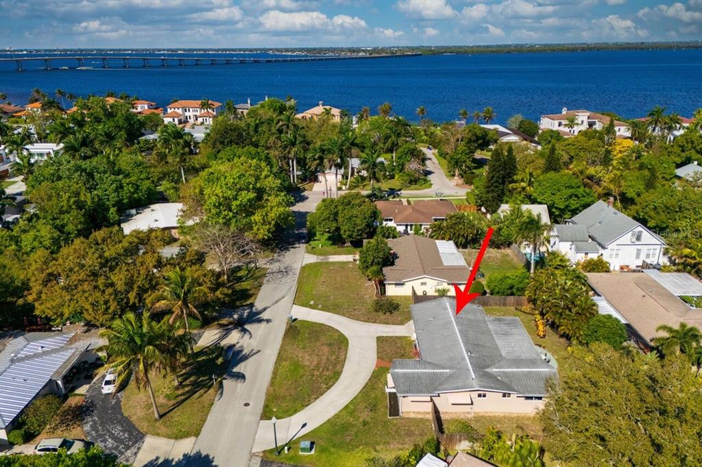 An aerial view shows a residential house with a gray roof near a large body — 19808 FRENCHMANS COURT, NORTH FORT MYERS, FL
