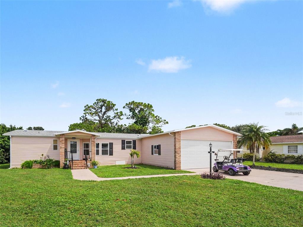 A single-story light pink house with a two-car garage and a golf cart parked outside — 19808 FRENCHMANS COURT, NORTH FORT MYERS, FL