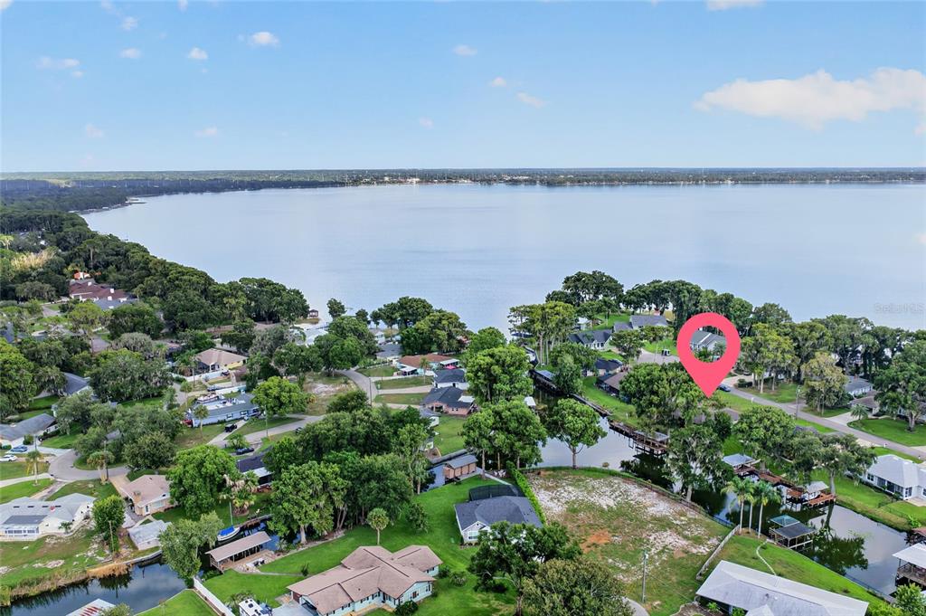 This is an aerial view of a residential neighborhood situated along a large lake — 235 TEMPLE CIRCLE, EUSTIS, FL