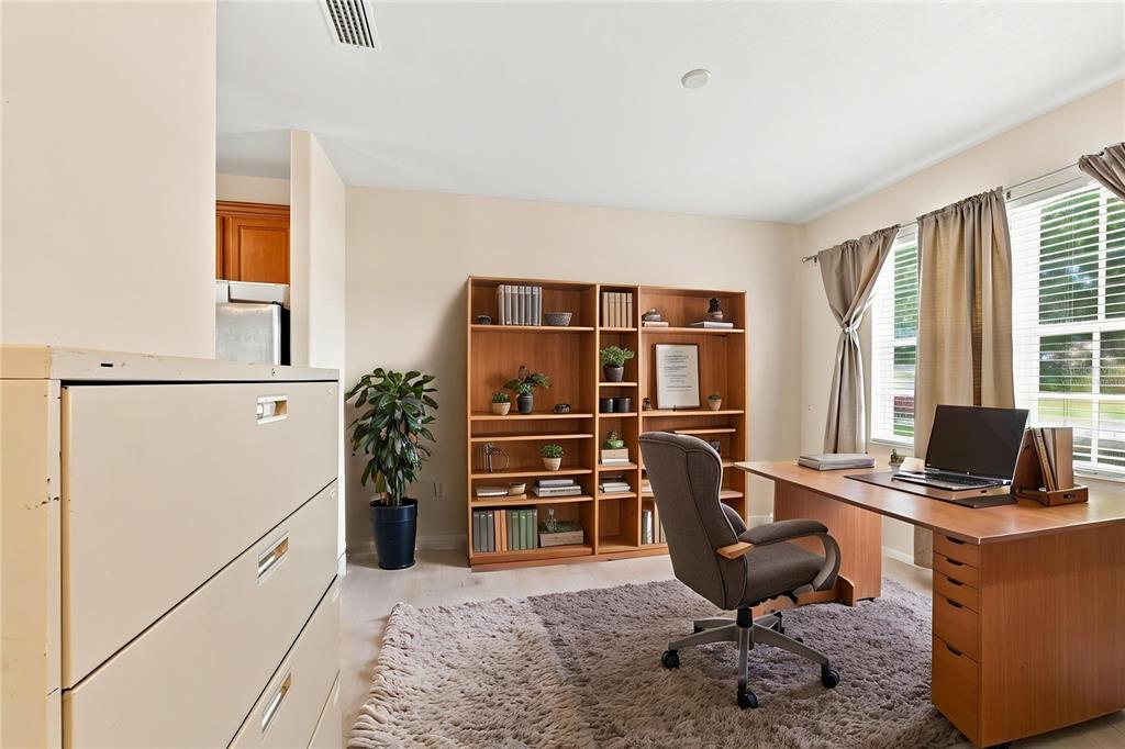 A home office features a wooden desk, a bookshelf, a filing cabinet, and a rug — 4469 STONEY RIVER DRIVE, MULBERRY, FL