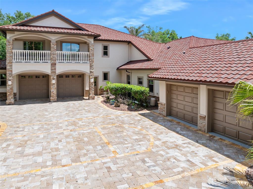 A large house with a paver driveway, four garage doors, and a second-story balcony — 3513 KILGALLEN COURT, ORMOND BEACH, FL