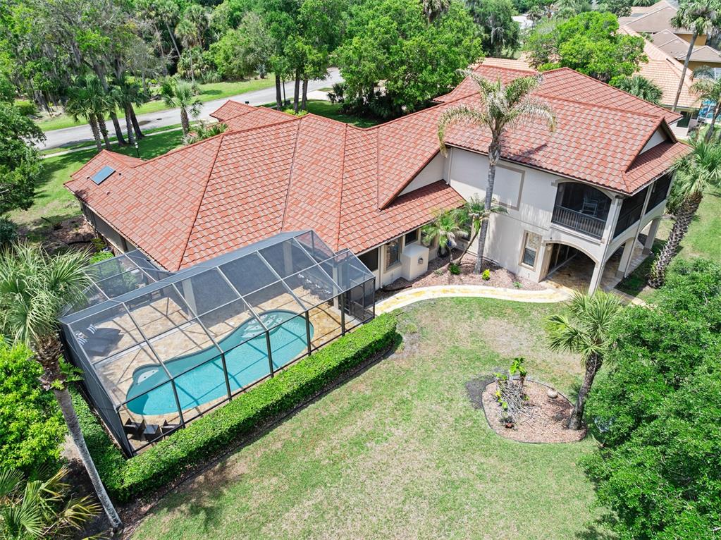 An aerial view of a house with a red tile roof and a screened-in pool — 3513 KILGALLEN COURT, ORMOND BEACH, FL