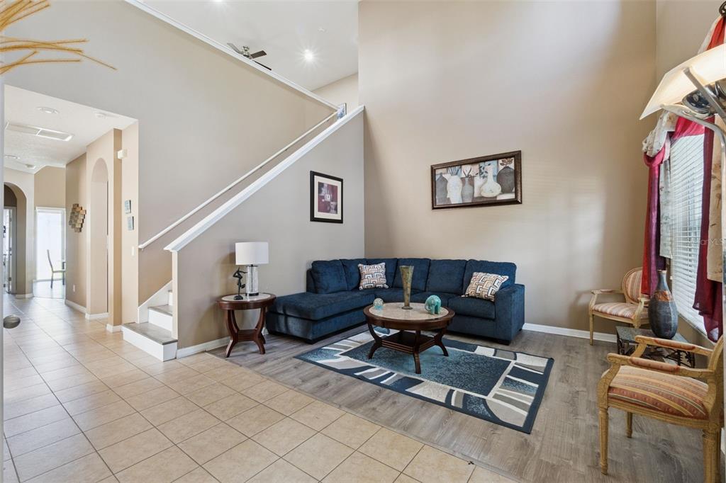 A living room features a blue sectional sofa, a coffee table, and a staircase — 351 MICHIGAN ESTATES CIRCLE, ST CLOUD, FL