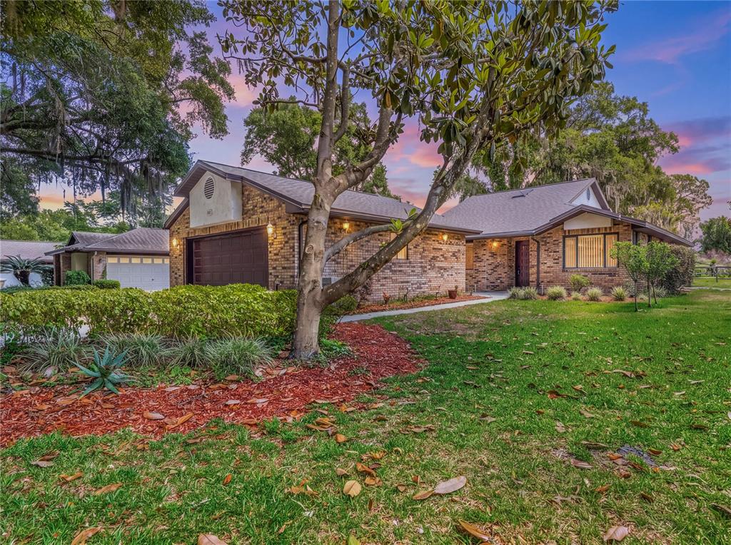 A brick house exterior features a recessed front door with square panels and a window — 109 WATERWOOD DRIVE, YALAHA, FL