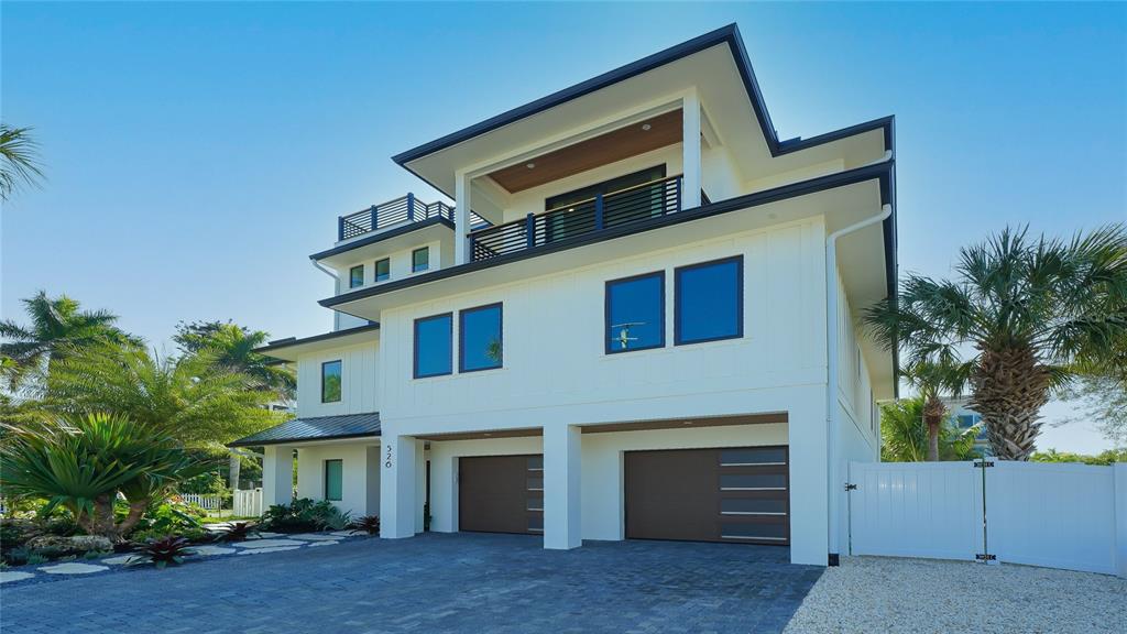 A three-story modern white house with a two-car garage and a balcony — 307 62ND STREET, HOLMES BEACH, FL