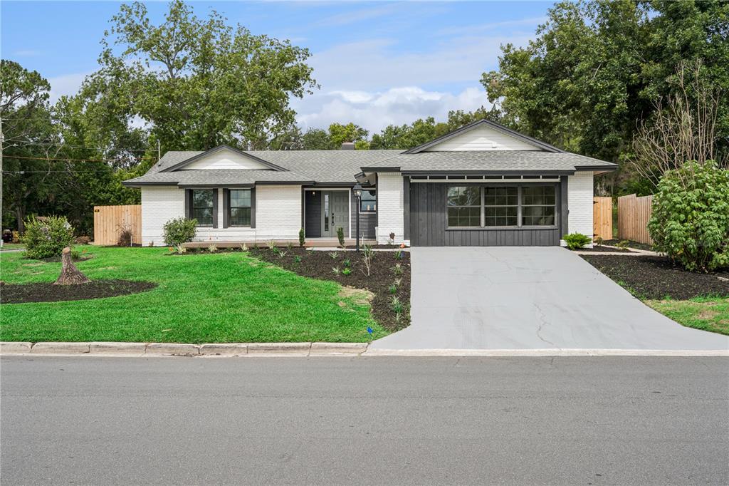 A single-story white brick house with a gray roof and a front-facing concrete driveway — 1500 WEST AVENUE, CLERMONT, FL