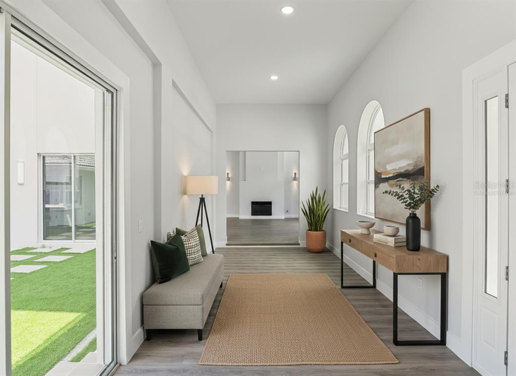 A living room features a stone fireplace, light wood-look flooring, and glass double doors — 1190 W LAKESHORE DRIVE, CLERMONT, FL