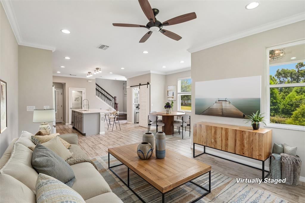 An entryway features a white barn door, light wood-look tile flooring, and two glass-paneled doors — 6706 ROCKY PARK STREET, TAMPA, FL