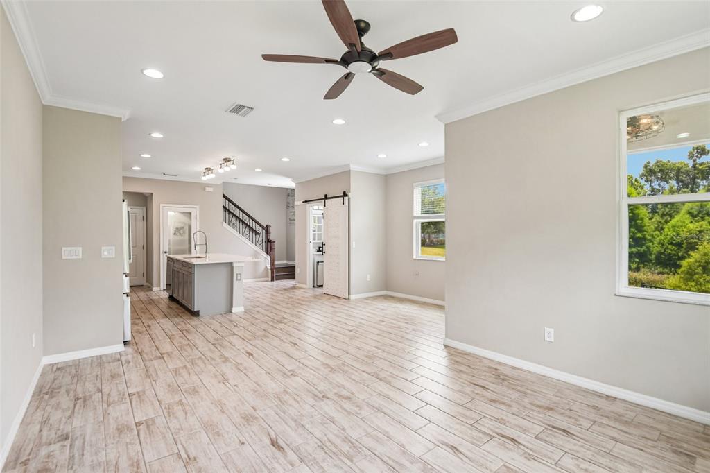 This open-concept living and dining area features wood-look tile flooring and a modern kitchen — 6706 ROCKY PARK STREET, TAMPA, FL