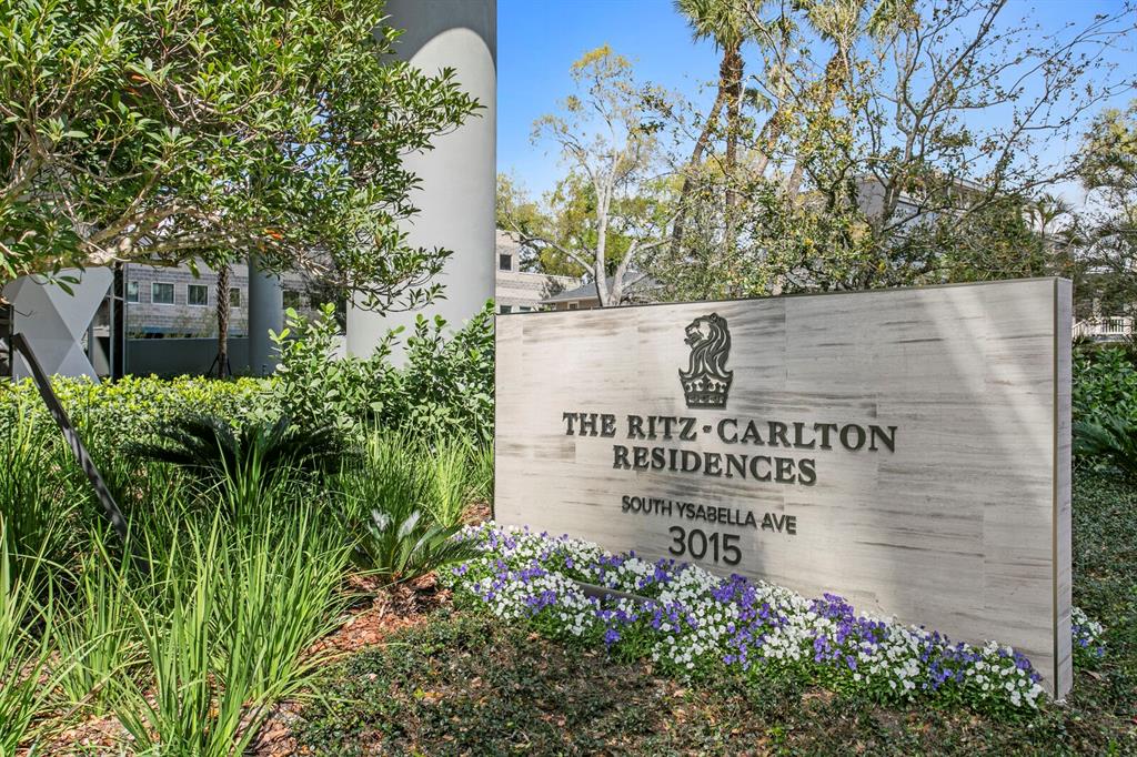 A sign for The Ritz-Carlton Residences stands in a garden with flowers and trees — 3015 S YSABELLA AVENUE UNIT 2402, TAMPA, FL