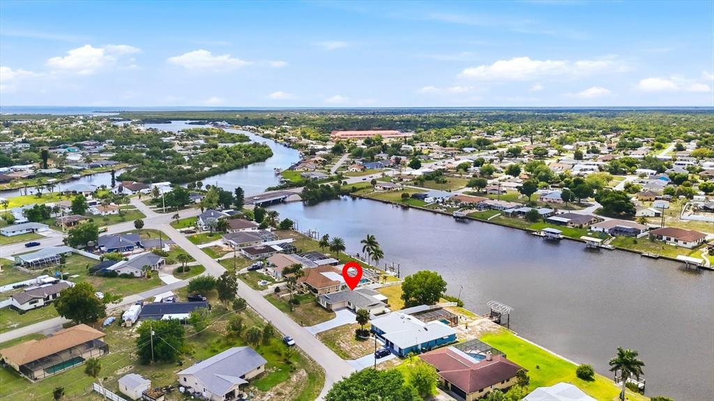 An aerial view shows a residential neighborhood with a canal and a marked house — 814 ELLICOTT CIRCLE NW, PORT CHARLOTTE, FL