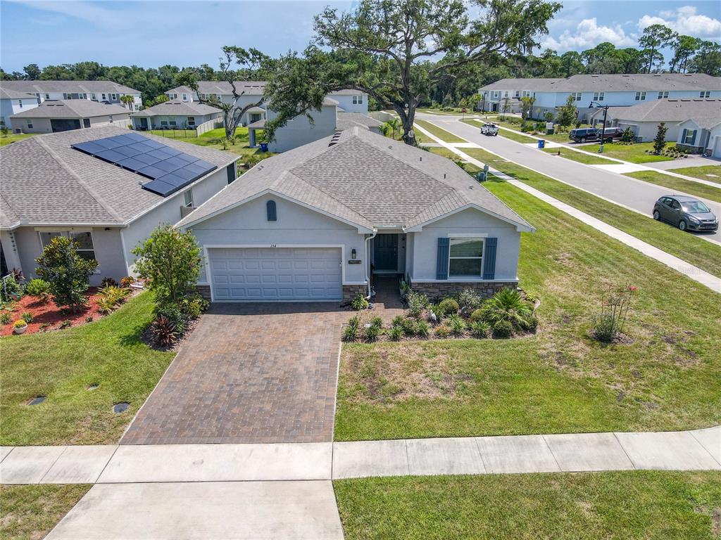 An aerial view shows a single-story suburban house with a paved driveway and shingled roof — 154 JONES FISH CAMP ROAD, EDGEWATER, FL