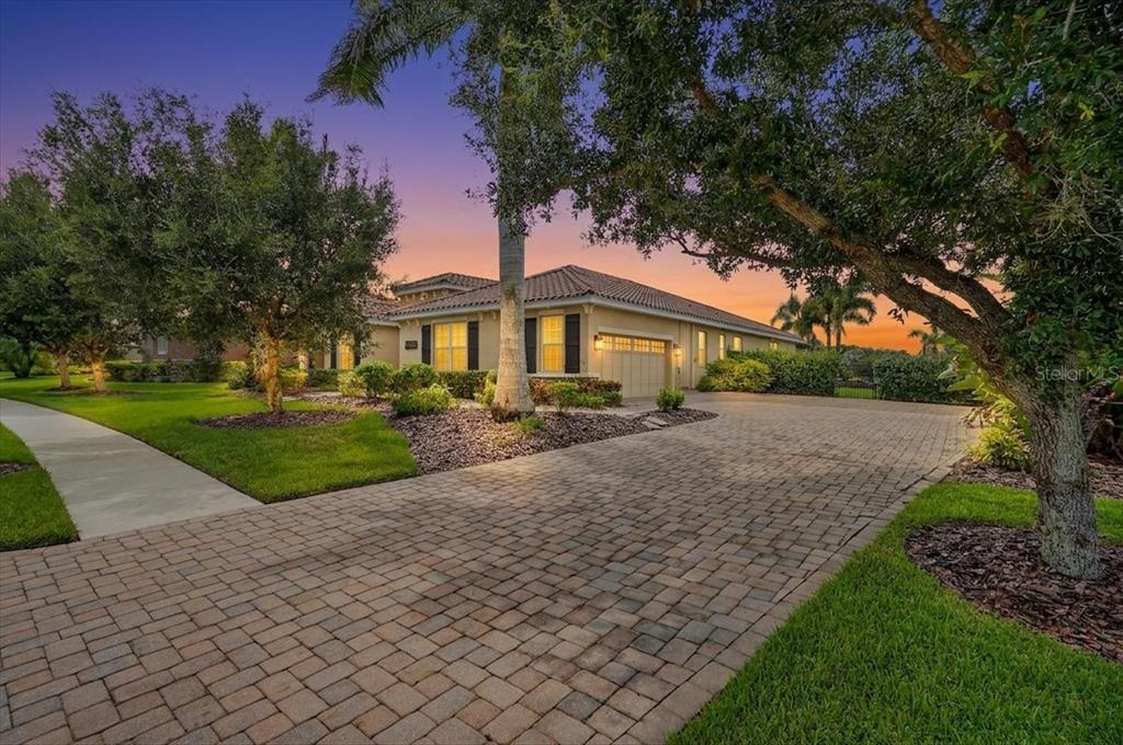 A single-story house with a paved driveway and a tile roof at sunset — 17009 1ST DRIVE E, BRADENTON, FL
