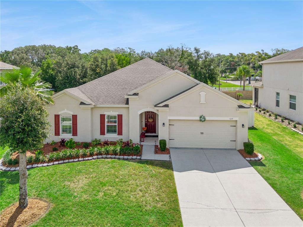 A single-story house with a beige stucco exterior, red shutters, and a two-car garage — 637 BAY BRIDGE CIRCLE, APOPKA, FL