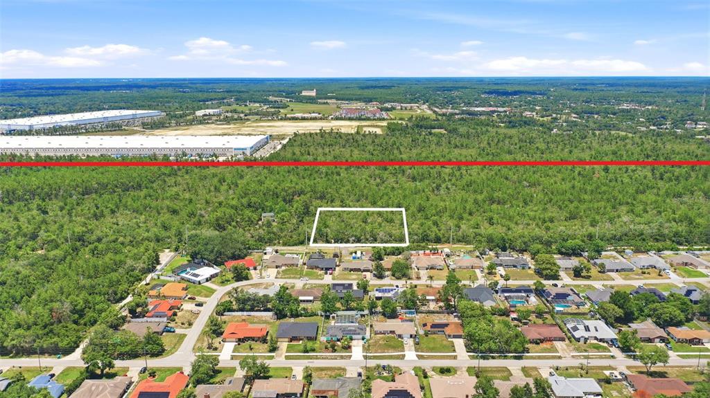 An aerial view shows a rectangular plot of land outlined in white amidst a wooded area — SOUTH AVENUE, DELTONA, FL