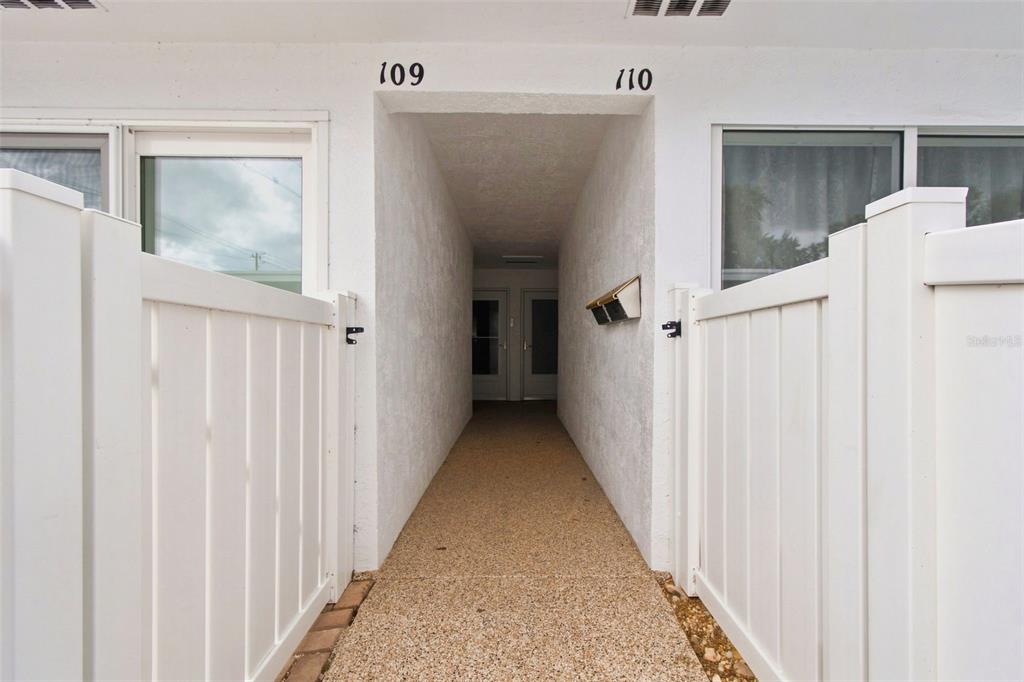 A narrow outdoor walkway leads to two unit doors labeled 109 and 110 — 1655 S HIGHLAND AVENUE UNIT B110, CLEARWATER, FL